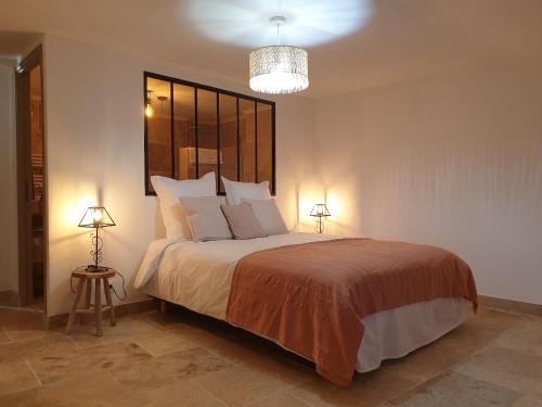 CaderousseMAS DU RECATI的一间卧室配有一张大床和两盏灯