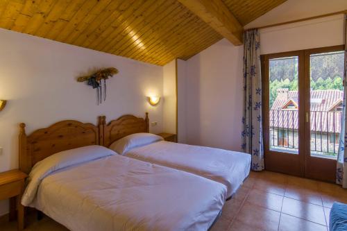 特尔河畔比拉利翁加卡梅斯特旅馆的一间卧室设有两张床和窗户。