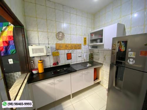 圣路易斯Guarnicê Hostel的厨房配有白色橱柜和不锈钢冰箱