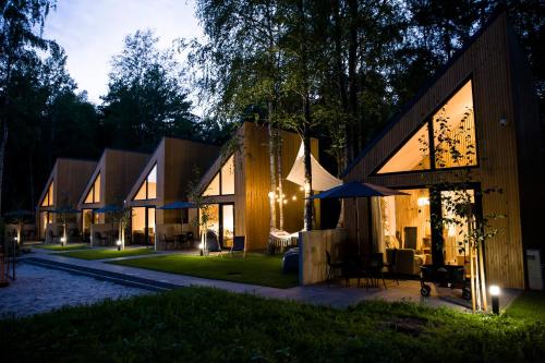 梅尔诺Village Mielno - najpiękniejsze domki wakacyjne nad morzem的夜晚带庭院的房子