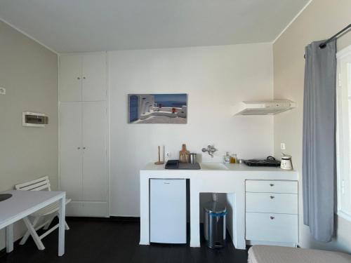 科里夏AEGEAN VIEW SEASIDE ROOMS AND STUDIOS KEA的白色的厨房配有水槽和桌子
