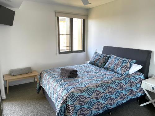 达尔文Serenity Zealandia - Luxury 1brm unit at Darwin Waterfront的一间卧室设有一张床和一个窗口