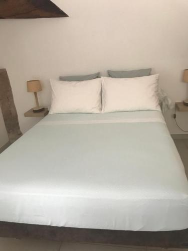 阿洛Ma maisonnette的一张带白色床单和枕头的床