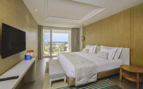 哈马马特Royal Azur Thalassa的酒店客房设有一张大床和一台电视。