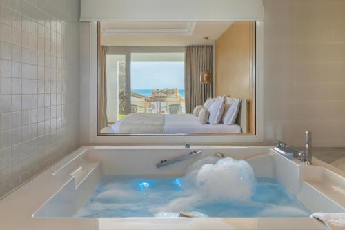 哈马马特Royal Azur Thalassa的配有床的酒店客房内的浴缸