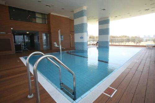 阿什杜德West All Suites Hotel Ashdod的一座铺有木地板的建筑中的大型游泳池