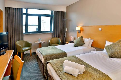 诺丁汉华美达诺丁汉市中心酒店的酒店客房设有两张床和电视。