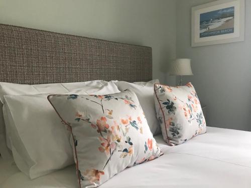 彭赞斯Tregiffian Farm B&B的一张带两个白色枕头的床,上面有鲜花