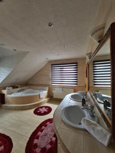 下乌斯奇基Apartament Katarina 2的大型浴室设有两个盥洗盆和浴缸。