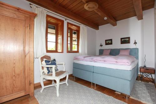 阿伦斯霍普Fachwerkhaus的一间卧室配有蓝色的床和椅子