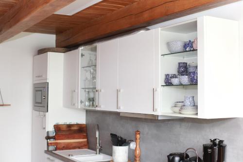 阿伦斯霍普Fachwerkhaus的厨房配有白色橱柜和水槽
