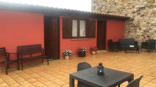 SeñaPosada El Nozal的庭院设有桌椅和红色墙壁。