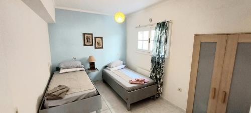 阿纳维索斯The Athenian Riviera Summer Nest的客房设有两张床和窗户。