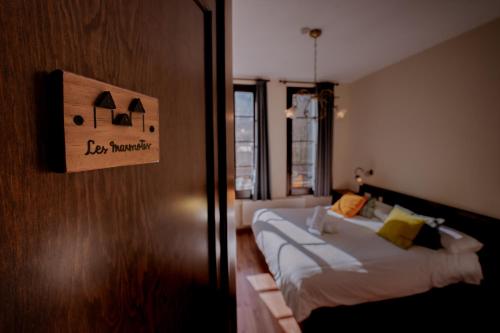 坎普罗东Hotel Mas de Xaxas的一间设有两张床的客房,墙上有标志