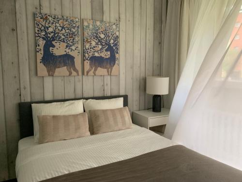 蒂黑Mały Kwadrat Tychy的卧室配有一张床铺,墙上挂有两幅鹿画