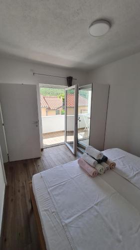 格雷巴蒂卡Apartmani Mlinar - One bedroom apartment with seaview的一间卧室配有带毛巾的床