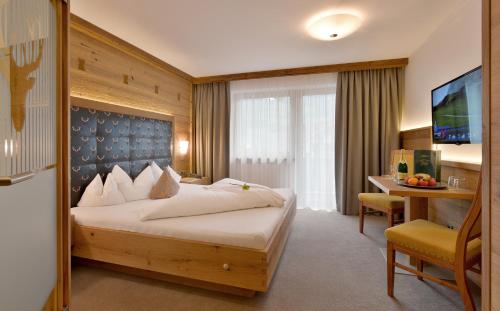 施利特尔斯Hotel Gasthof Jäger Zillertal的配有一张床和一张书桌的酒店客房