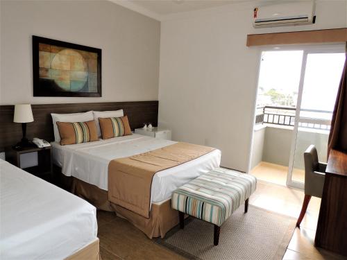 卡舒埃拉保利斯塔Hotel Água Viva - By UP Hotel的酒店客房设有两张床和窗户。