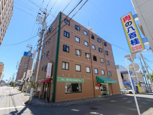 磐田市Tabist IWATA Station Hotel的城市街道拐角处的建筑物