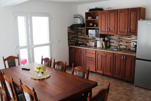SăcueniVILA ONIX的厨房配有木桌和冰箱。