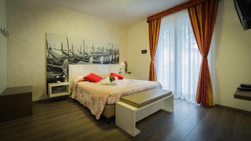 卡奥莱威尼斯酒店的一间卧室配有一张带红色枕头的床