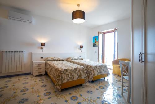 斯卡拉CASA ALBA D'ORO的一间卧室设有两张床、一个梳妆台和窗户。