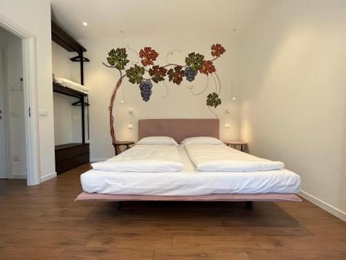 加尔达湖滨Agritur Fiore d'Ulivo的卧室配有一张挂在墙上的植物床