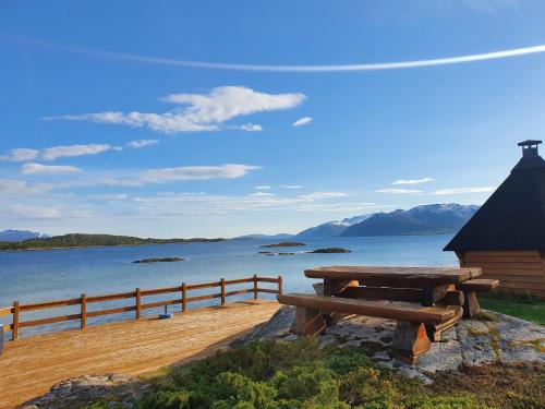 BrygghaugenOff-the-grid cabin on the island of Senja in northern Norway的水体旁边的野餐桌