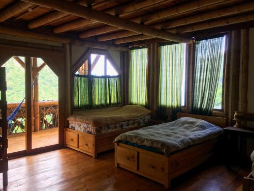 TzununáBambu Guest House的一间带两张床的卧室,位于带窗户的房间内