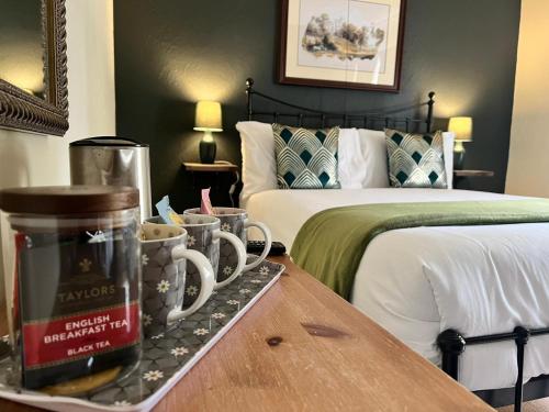 贝克韦尔Red Lion的一间酒店客房,配有两张床和咖啡杯盘