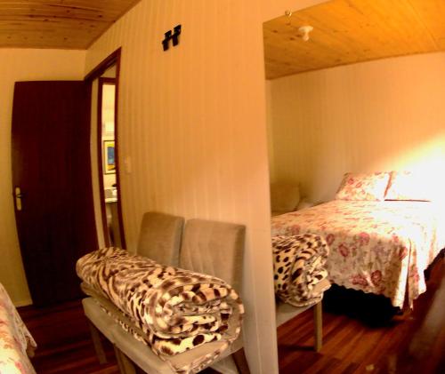南卡希亚斯Cabana das Montanhas的卧室配有床、镜子和椅子