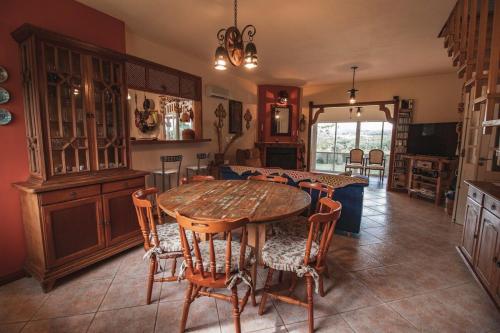 兰舒凯马杜Casa Fuchsia Régia em Rancho Queimado/SC的一间带木桌和椅子的用餐室
