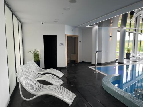 科沃布热格Apartament w Westin House Resort Kołobrzeg的大堂设有两把白色椅子和游泳池