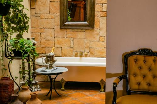 瓜达拉哈拉甘兹别墅精品酒店 的带浴缸、桌子和椅子的浴室