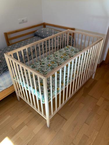 欧德鲁佐Pilgrim’s House的铺有木地板的客房内的小婴儿床