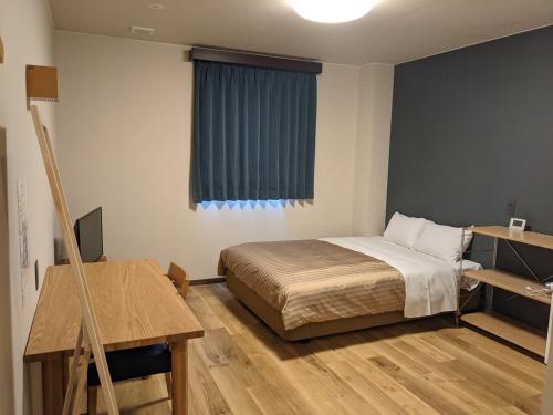 藤枝Fujieda Ogawa Hotel - Vacation STAY 29634v的一间卧室配有一张床、一张书桌和一个窗户。