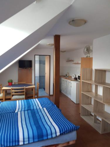 特热邦Penzion U Polenů的一间带蓝色和白色床的卧室和一间厨房