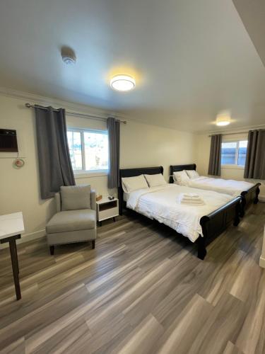 镭温泉Destination INN的一间卧室配有两张床和椅子