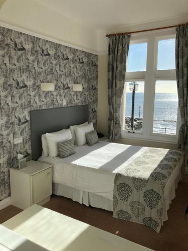 锡德茅斯Bedford Hotel的一间卧室设有一张大床,享有海景