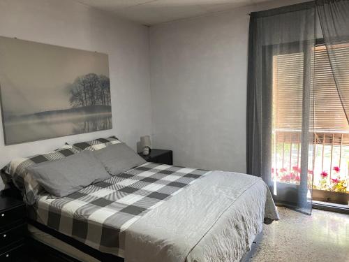 鲁维Apartamento entero con terraza en el centro de Rubí的一间卧室设有一张可调节的床和一扇窗户。