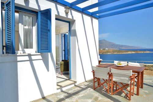 加夫里翁Andros Homes Sea Side Apartment & Studio的一个带桌椅的庭院,享有水景