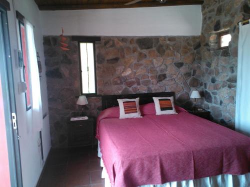 圣马科斯塞拉Kailash Posada的一间卧室配有一张石墙床