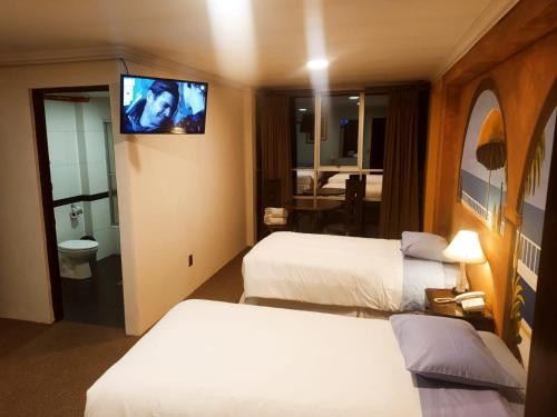拉巴斯Terraza Hotel的酒店客房设有两张床和一台平面电视。