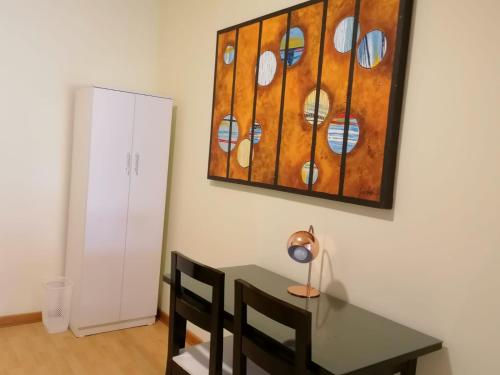 利马Miraflores Rooms的一间设有桌子和墙上绘画的用餐室