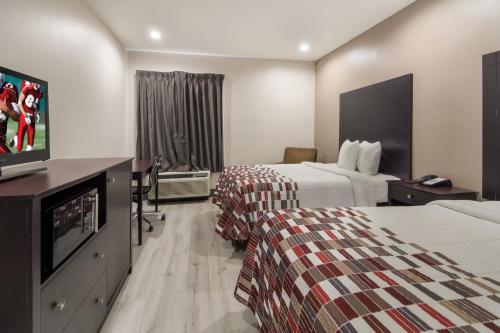 特勒尔Red Roof Inn Terrell的酒店客房设有两张床和一台平面电视。