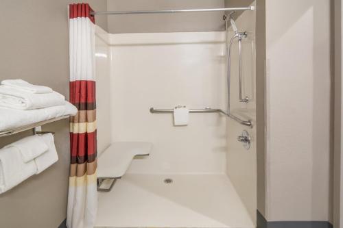 特勒尔Red Roof Inn Terrell的带淋浴、卫生间和毛巾的浴室