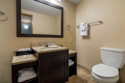 坎卢普斯坎卢普斯加酒店的一间带卫生间、水槽和镜子的浴室