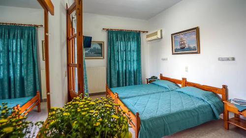 斯科拉埃菲酒店的一间卧室配有一张带蓝色床单和窗户的床。