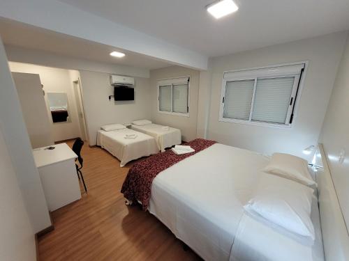 加里波第Pousada dos Frades的酒店客房设有两张床和窗户。
