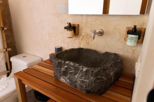 图卢姆Koos Hotel Tulum的浴室设有木桌上的黑色浴缸